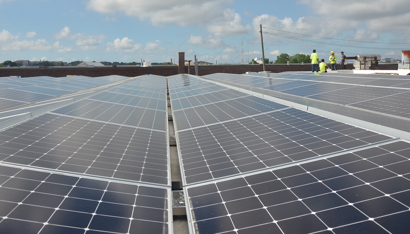 Slanted solar panels, workers in the distance