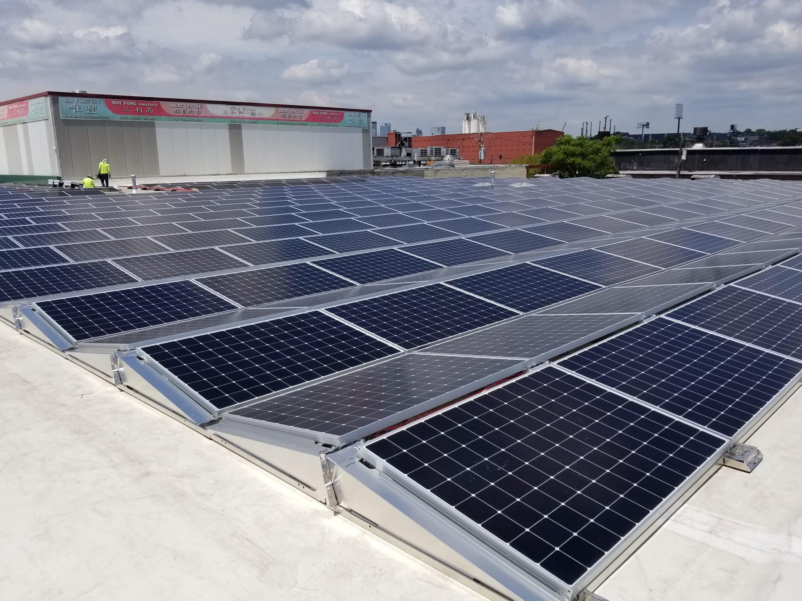 Solar panels on roof, two workers in the distance